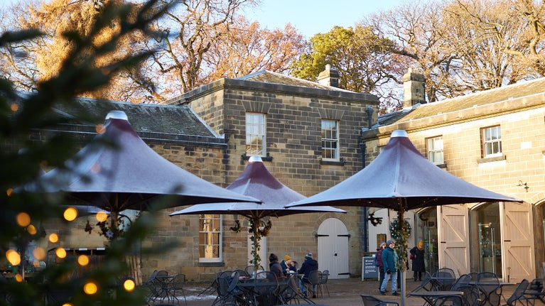 The stables courtyard at Nostell decorated for Christmas with visitors in the background